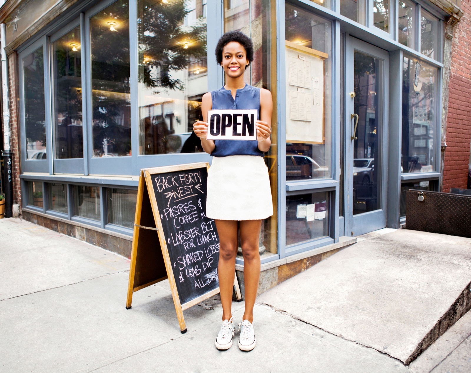 Woman outside of restaurant open for business